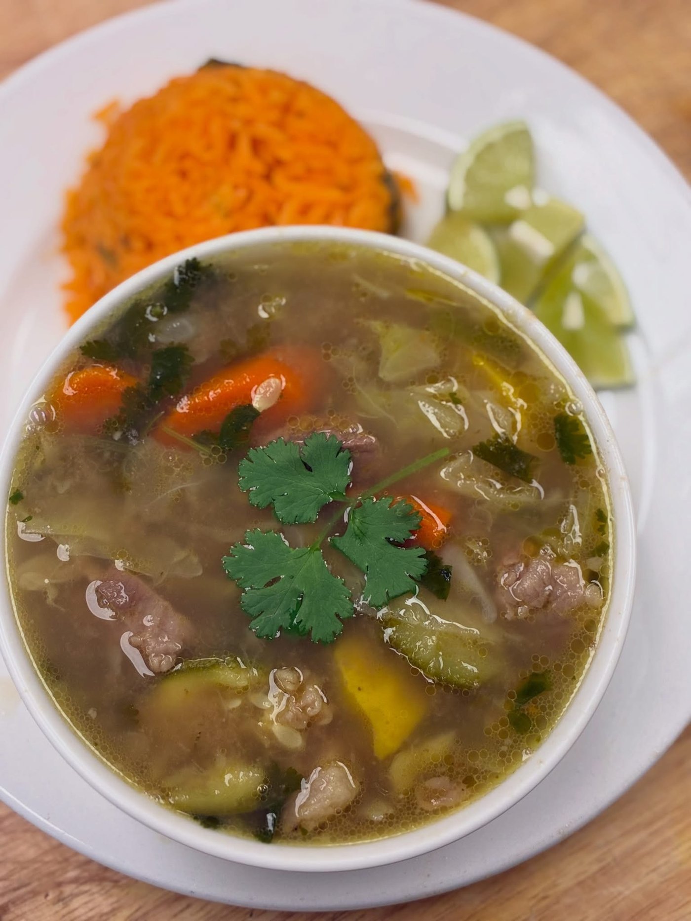 Bowl of Caldo de Res with rice and lime